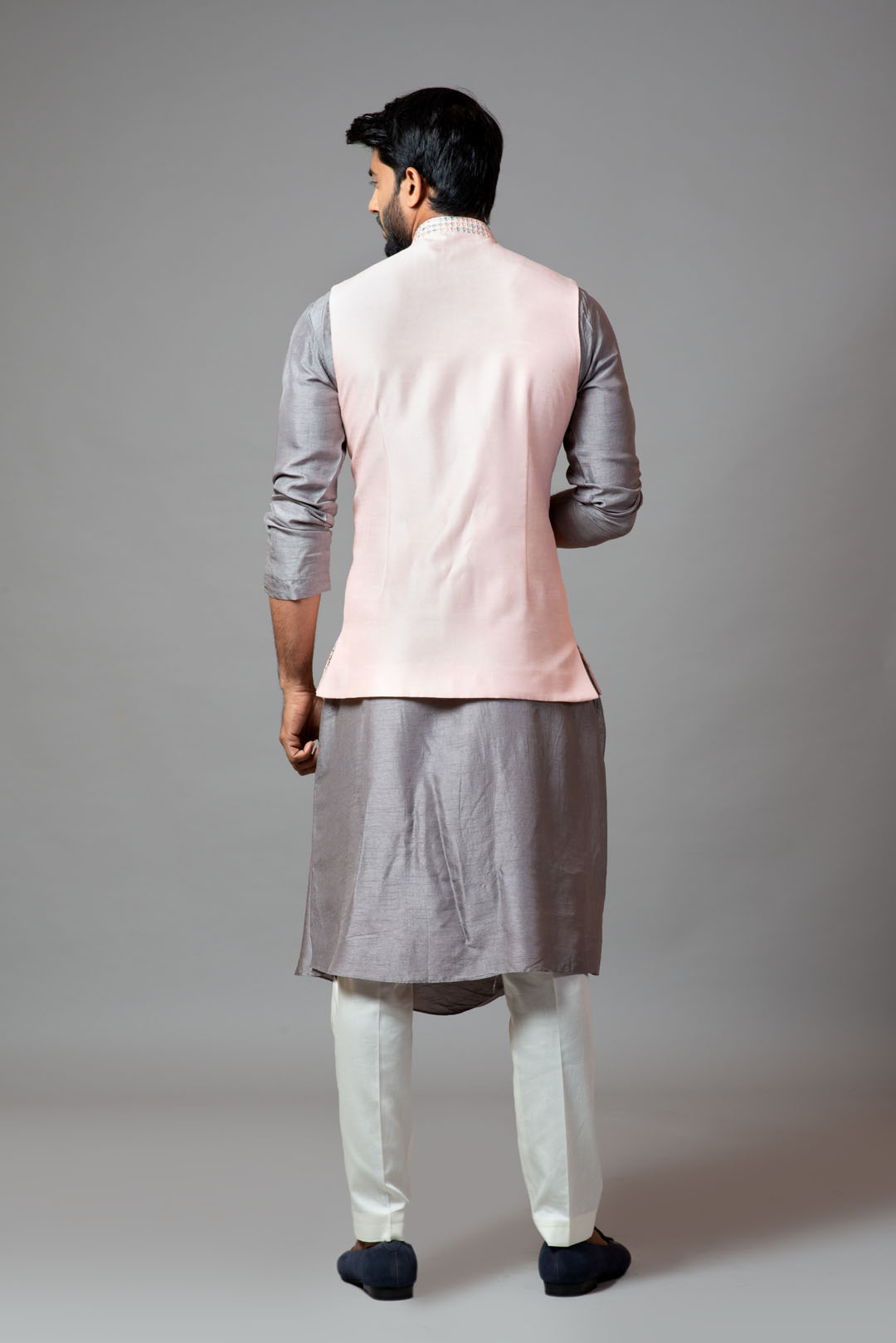Powder pink Nehru jacket with geometric Mirrorwork embroidery paired with a slate grey drape kurta and pant pajama